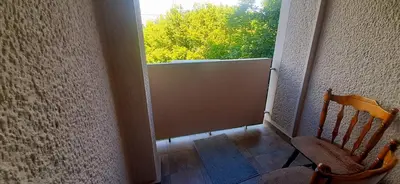 a room with a door and a chair and a window at Apartman Studenjak in Tošin Bunar