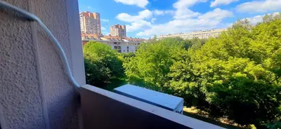 a bench on a balcony with a view of trees at Apartman Studenjak in Tošin Bunar