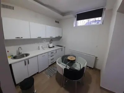 a kitchen with white cabinets and a table and a sink at XENIA2 in Belgrade