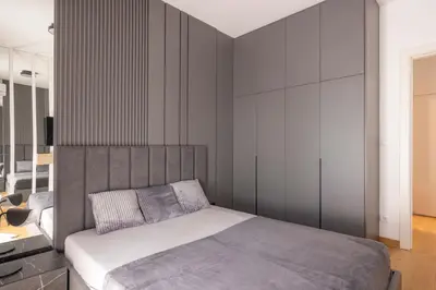 a bedroom with a bed with a gray headboard at N65 LUX Apartment in Belgrade