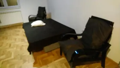a black table and a chair with a white phone on it at Stan Ledine 65m2 in Novi Beograd