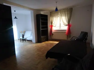 a living room with a table and a window at Stan Ledine 65m2 in Novi Beograd