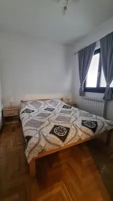 a bedroom with a bed in a room with a window at Stan Na Dan 022 in Inđija