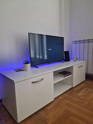 a white entertainment center with a large television on it at Stan Na Dan 022 in Inđija