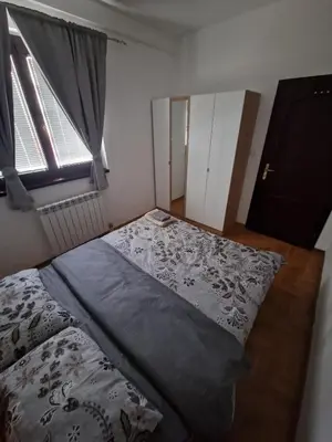 a bedroom with a bed and a window at Stan Na Dan 022 in Inđija