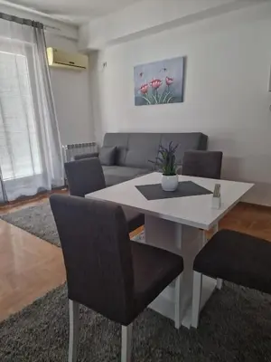 a living room with a white table and chairs at Stan Na Dan 022 in Inđija