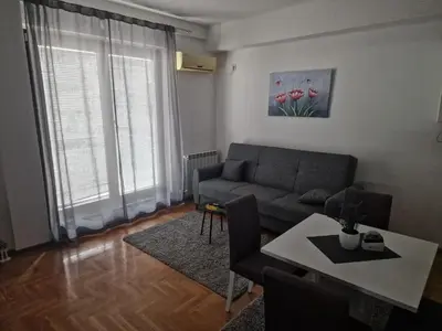 a living room with a couch and a table at Stan Na Dan 022 in Inđija