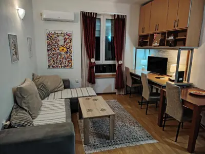 a living room with a couch and a table and a desk at Dorcol-Basic Apartman in Belgrade