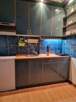 a kitchen with blue tiled walls and stainless steel cabinets at Dorcol-Basic Apartman in Belgrade