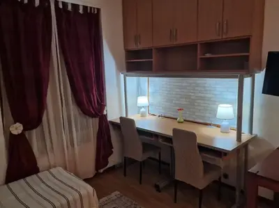 a room with a desk with chairs and a window at Dorcol-Basic Apartman in Belgrade