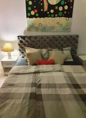 a bedroom with a bed with a painting on the wall at Lavanda in Belgrade