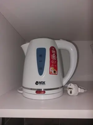 a white tea kettle sitting on a shelf at Tiny Apartment in Belgrade