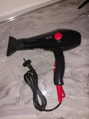 a black hair dryer with a cord on a table at Tiny Apartment in Belgrade