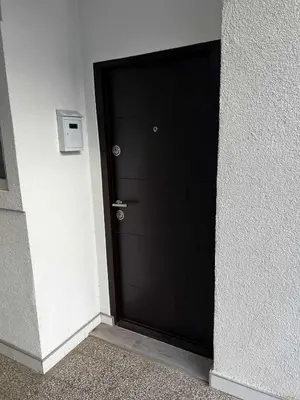 a black door in a room with a wall at Tiny Apartment in Belgrade