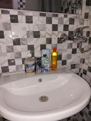 a bathroom sink with toiletries on top of it at Tiny Apartment in Belgrade