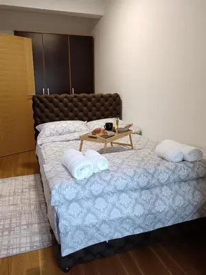 a bedroom with a large bed with a table on it at Zemun residence in Novi Grad