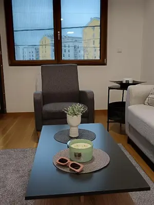a living room with a table with a bowl and pair of slippers at Zemun residence in Novi Grad