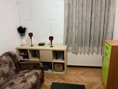 a living room with a book shelf with two glasses of wine at Apartmani Vlaška in Vlaška
