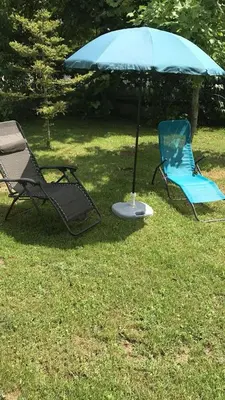 two chairs and an umbrella in the grass at Apartmani Vlaška in Vlaška