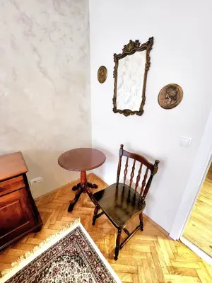 a room with a chair and a mirror on the wall at Erste City Apartment in Sajmište