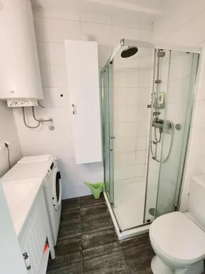 a bathroom with a shower and a toilet at Erste City Apartment in Sajmište