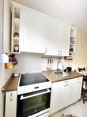 a kitchen with white cabinets and a sink at Erste City Apartment in Sajmište