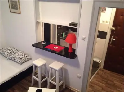 a small room with a bed with stools and a table at BelgradeCity center-Lekic apart 1 in Belgrade