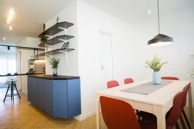a kitchen and dining room with a white table and red chairs at Victor Nest Double Room Apartment in Belgrade