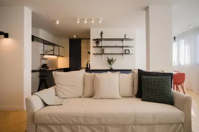 a living room with a white couch with pillows at Victor Nest Double Room Apartment in Belgrade