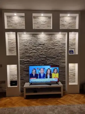 a flat screen tv in a room with a stone wall at Modern apartment - quiet street in Belgrade