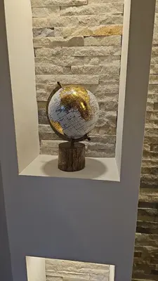 a globe on a stand in front of a brick wall at Modern apartment - quiet street in Belgrade