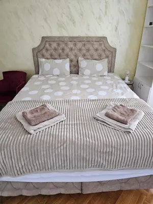 a large bed with two towels on top of it at Modern apartment - quiet street in Belgrade