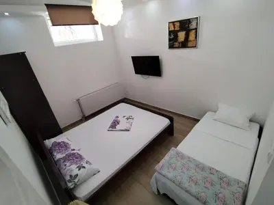 a small room with two beds and a tv at XENIA1 in Belgrade