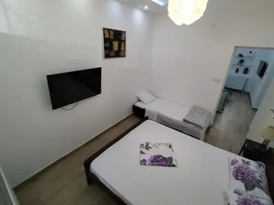 a living room with a table and a tv on a wall at XENIA1 in Belgrade