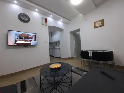 a living room with a table and a tv on a wall at XENIA1 in Belgrade