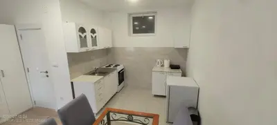 a small white kitchen with a sink and a stove at Zoka in Surčin