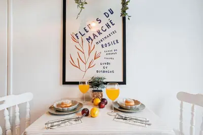 a table with two glasses of orange juice and food at Sunny Apartments with Terrace & River View Old Town in Belgrade