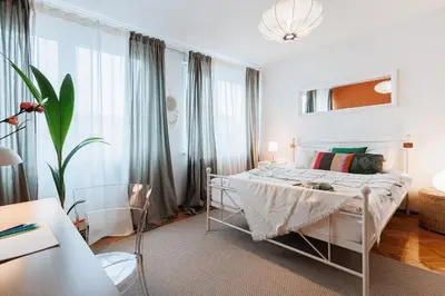 a white bedroom with a bed and a large window at Sunny Apartments with Terrace & River View Old Town in Belgrade