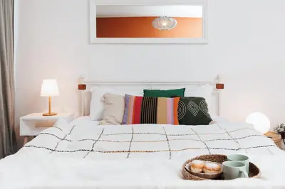 a white bed with a basket of donuts on it at Sunny Apartments with Terrace & River View Old Town in Belgrade
