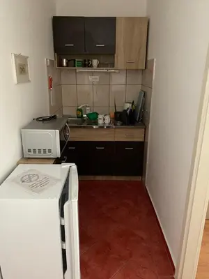 a small kitchen with a sink and a refrigerator at Rooms Jajinci in Belgrade