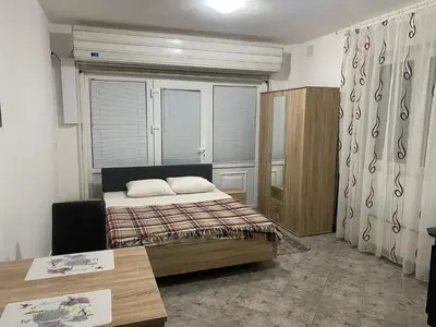 a bedroom with a bed and a table in it at Rooms Jajinci in Belgrade