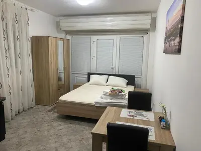 a bedroom with a bed and a table with chairs at Rooms Jajinci in Belgrade