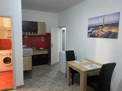 a kitchen and dining room with a table and a sink at Rooms Jajinci in Belgrade