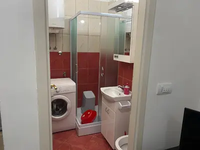 a small bathroom with a sink and a washing machine at Rooms Jajinci in Belgrade