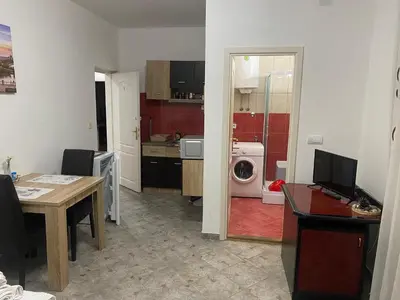 a kitchen with a table and a washing machine at Rooms Jajinci in Belgrade