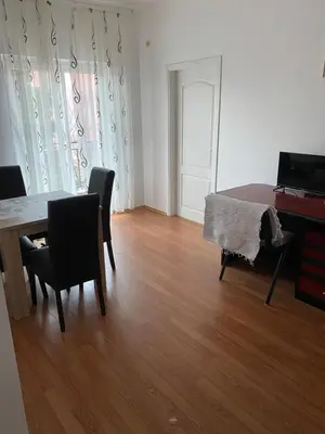a living room with a table and chairs and a piano at Rooms Jajinci in Belgrade