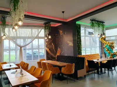 a dining room with tables and chairs and windows at Lux apartment A5 at nice location in Pancevo in Pančevo