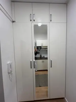 a white cabinet with a mirror in a kitchen at Nest in Sajmište