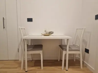 a white table with two chairs and a bowl on it at Nest in Sajmište