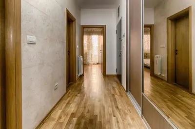 an empty hallway with wood floors and doors at Apartment 32 in Belgrade